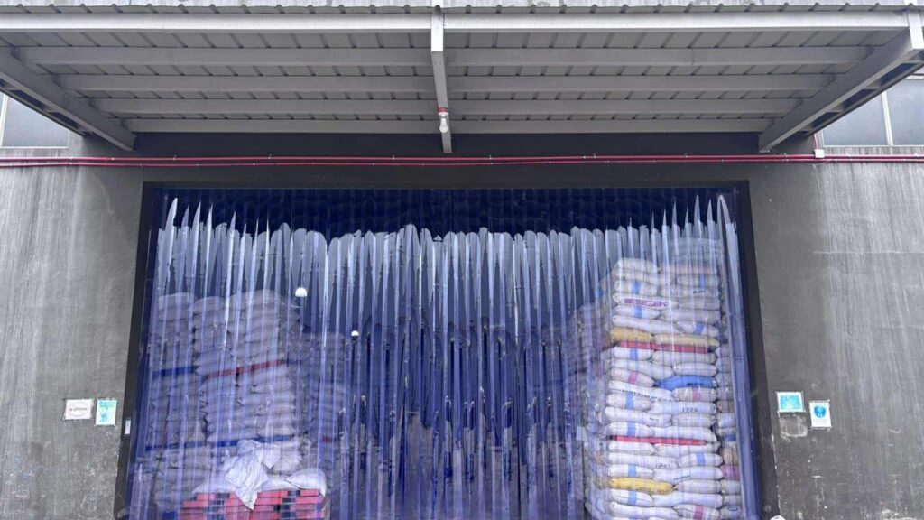 PVCPH photo of blue clear PVC strip curtains across a warehouse doorway