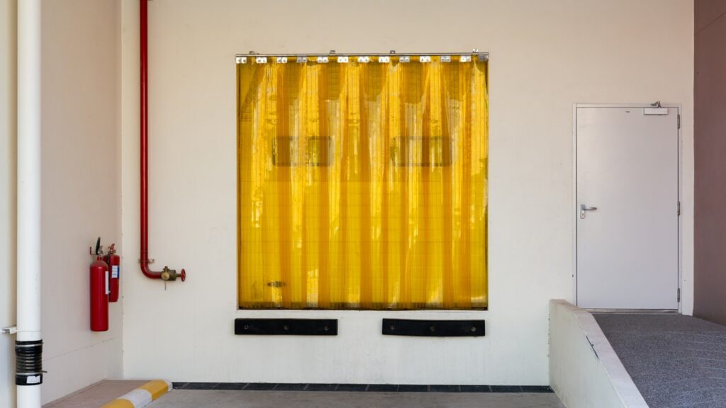 Stock photo of yellow transparent plastic strip curtains mounted on an industrial doorway